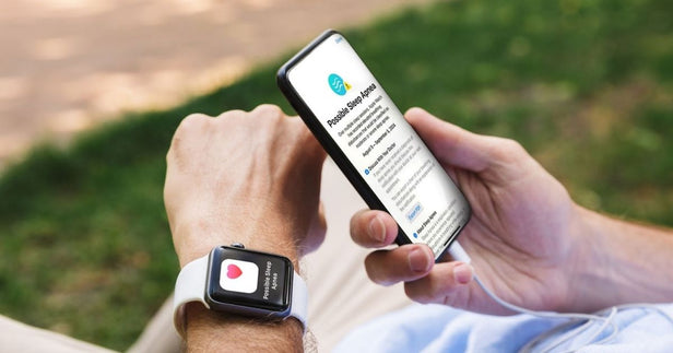 man is wearing apple watch paired with his iPhone while looking at sleep apnea detection screen