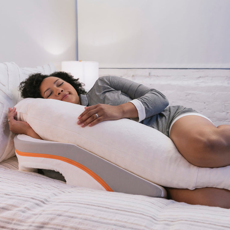 Woman peacefully sleeping on the MedCline Acid Reflux Relief Pillow, with wedge incline to aid acid reflux prevention during sleep. MedCline’s pillow offers a supportive sleep experience for those with GERD or similar conditions.