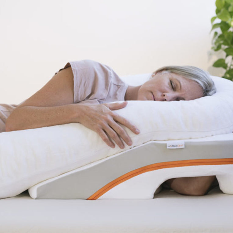 Woman resting comfortably on MedCline Acid Reflux Relief Pillow, specially designed to alleviate acid reflux and GERD symptoms by promoting an elevated, side-sleeping position. MedCline offers a doctor-recommended pillow for effective nighttime relief.