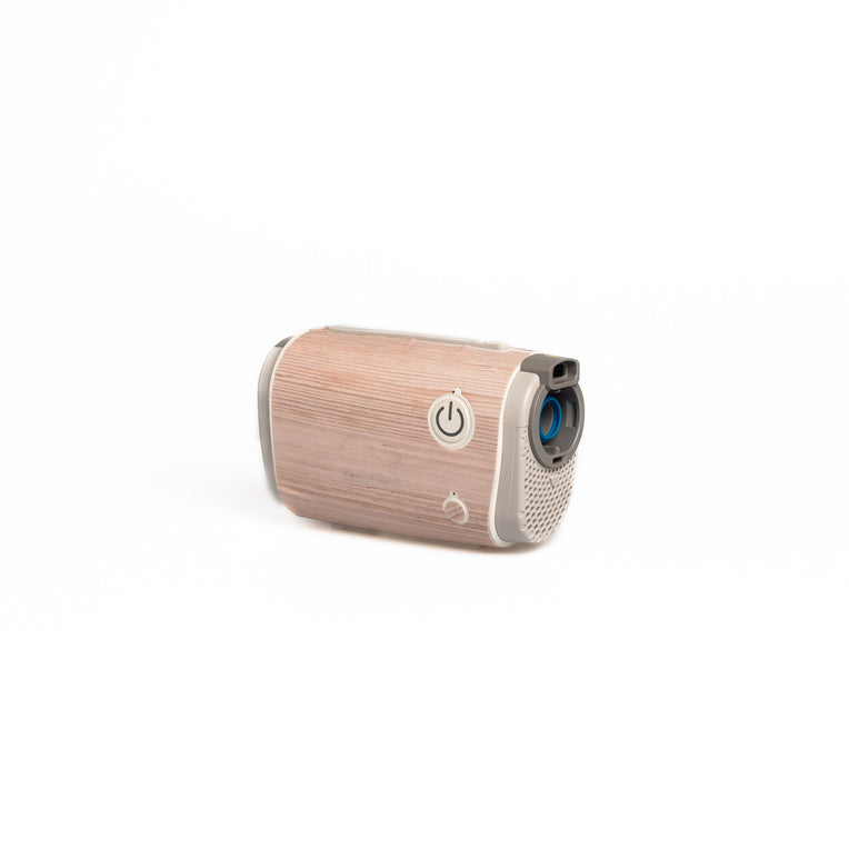 The AirMini Travel CPAP machine dressed in a light wood-patterned skin from Snugell. This subtle design provides a fresh and natural vibe, appealing to users who favor a soft, lightwood aesthetic for their travel essentials.