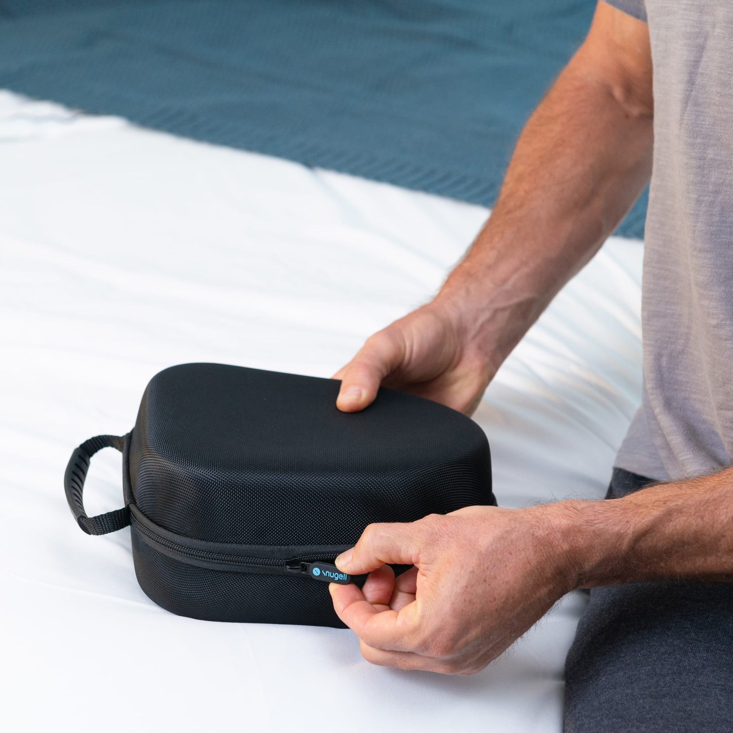 Person closing the Snugell CPAP Mask Storage Case, highlighting secure zipper closure for travel.