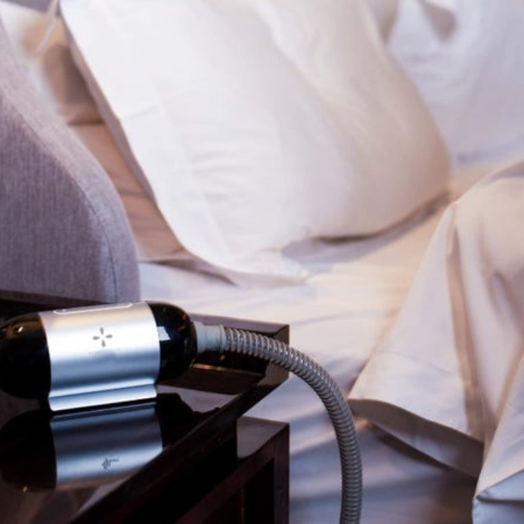 Luna TravelPAP CPAP Machine by React Health on a nightstand for a comfortable sleep experience.