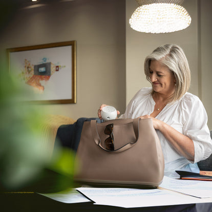 Smiling woman placing transcend micro travel cpap into large purse