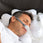 Man with CPAP nasal mask sleeps with CPAP Ergonomic Pillow